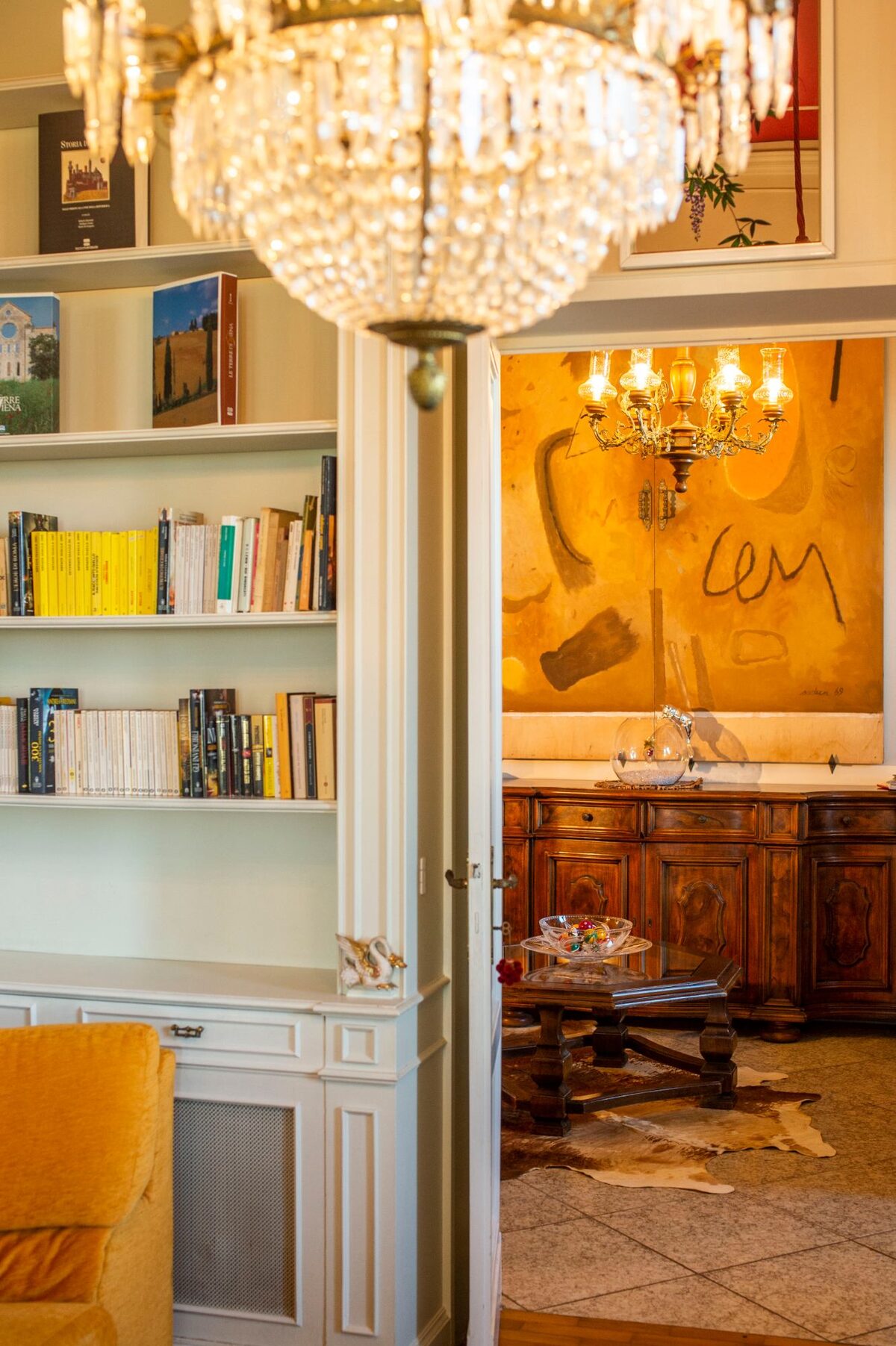 Biblioteca della villa con lampadario di cristallo e libreria bianca