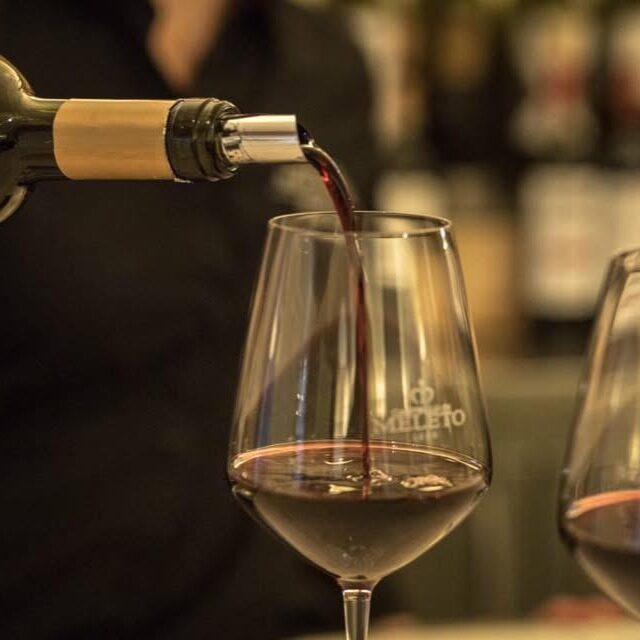 Vino rosso versato in un calice durante una degustazione