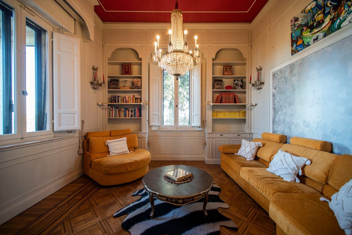 Salone di Dianora con divani, lampadario di cristallo e soffitto decorato