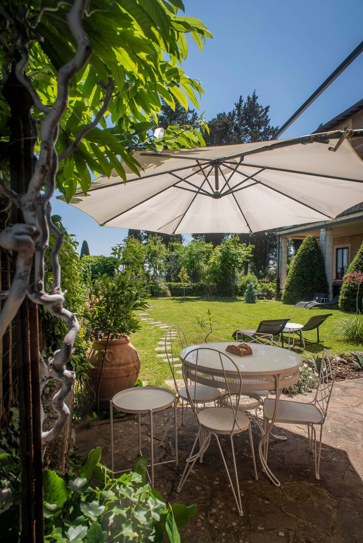Spazio comune: tavolo e ombrellone nel giardino della villa