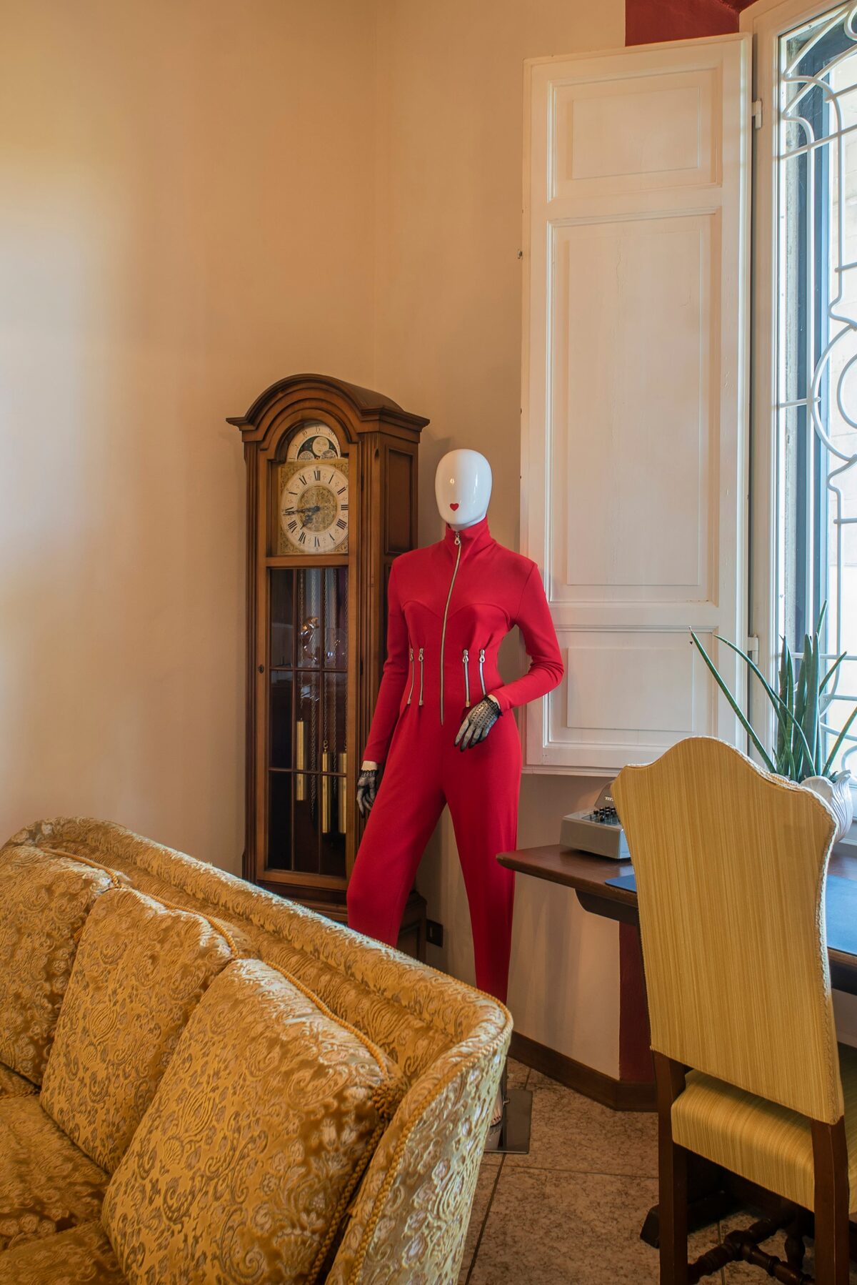 Interno della villa con manichino vintage, orologio a pendolo e poltrone d’epoca